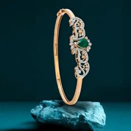 Gold bangle with emerald gemstone